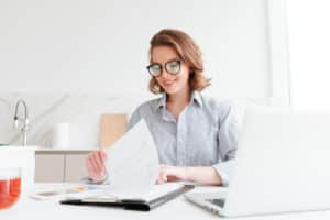 photo of cheerful attractive woman in glasses reading new contra